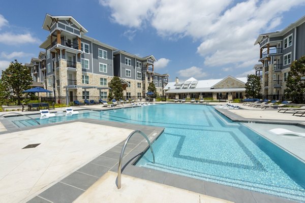 Outdoor pool with lounge chairs at Lakeside Row Apartments luxury community