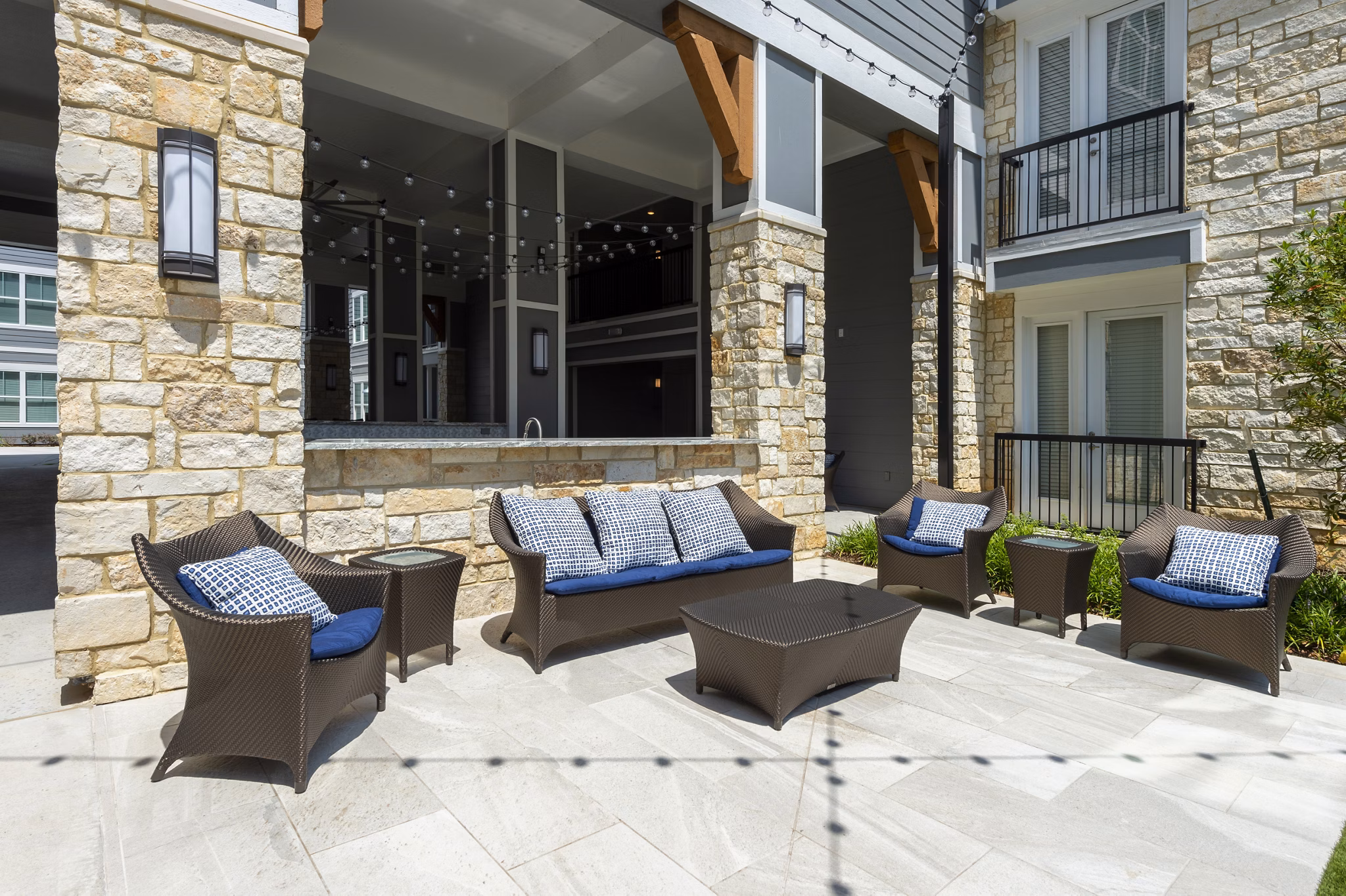 Patio with comfortable seating at Lakeside Row Apartments overlooking landscaped gardens