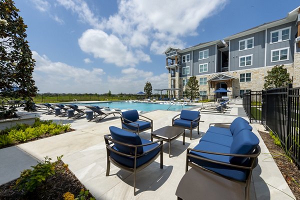 Outdoor poolside patio with lounge chairs at Lakeside Row Apartments, perfect for relaxation and social gatherings