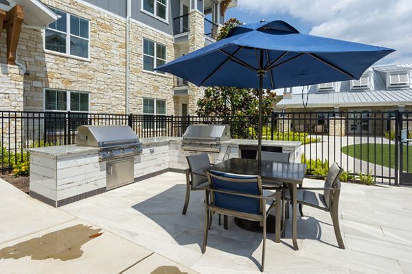 Outdoor grill and patio area at Lakeside Row Apartments, perfect for social gatherings and dining al fresco with scenic views