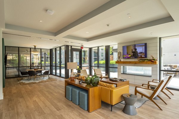 Modern clubhouse featuring cozy seating and large windows at The Lane at Waterway Apartments