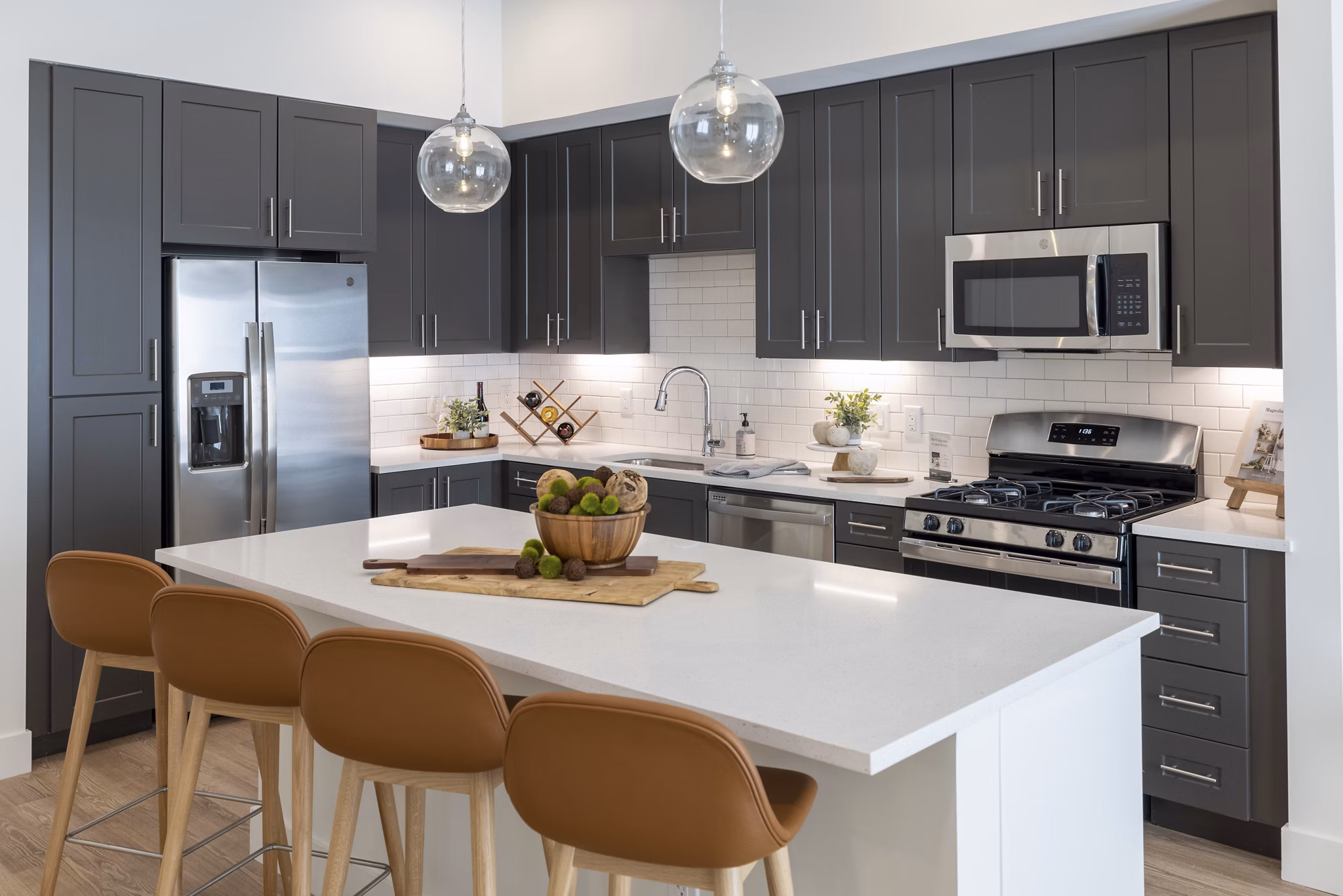 Kitchen featuring modern appliances and sleek countertops in The Lane at Waterway Apartments