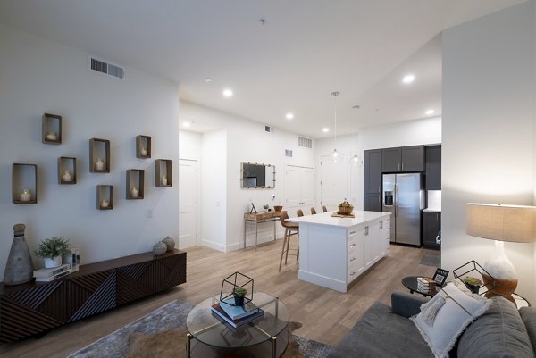 Cozy living room with modern decor at The Lane at Waterway Apartments, featuring plush seating and abundant natural light