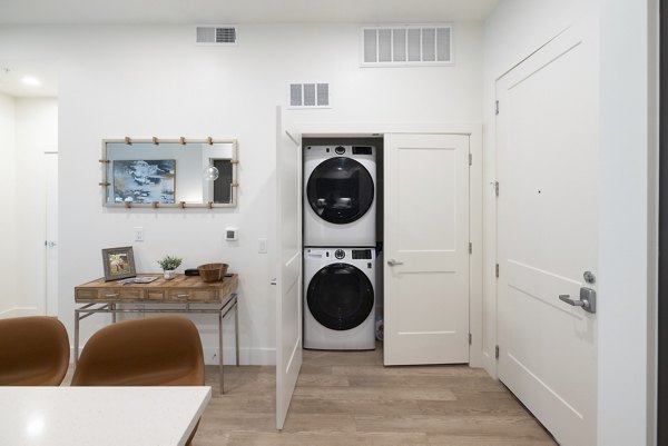 Laundry room with modern washers and dryers at The Lane at Waterway Apartments