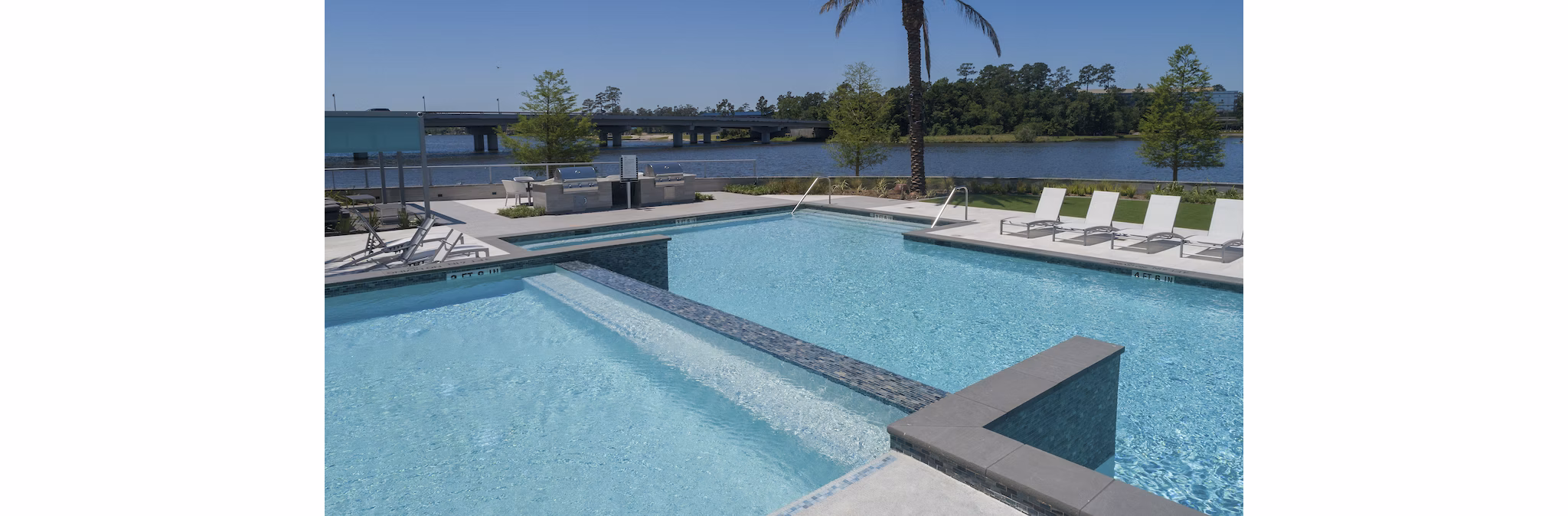 Resort-style pool with lounge chairs at Two Lakes Edge Apartments