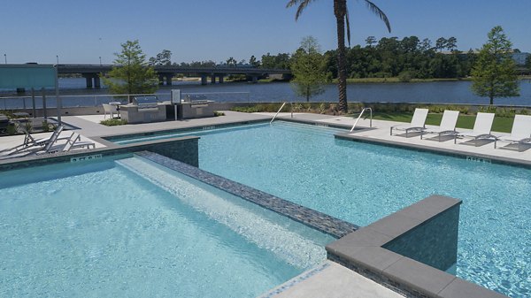 Resort-style pool with lounge chairs at Two Lakes Edge Apartments