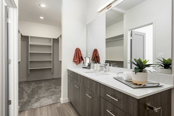 Modern bathroom with dual sinks and glass shower in Black Ridge Cove Apartments