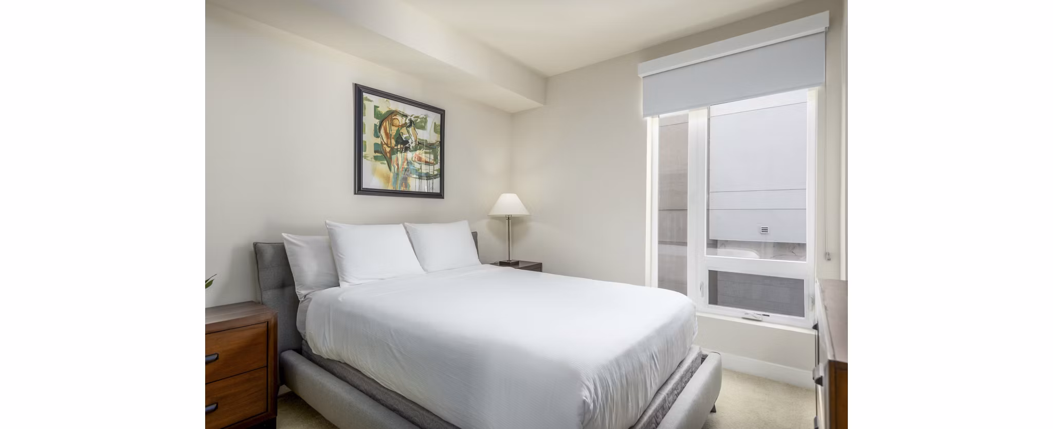 Bedroom featuring modern decor and large windows at mResidences Olympic & Olive Apartments, a Greystar luxury apartment community in a prime urban location