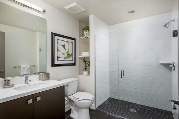 Modern bathroom featuring a sleek shower, stylish sink, and decorative plants in luxury apartments