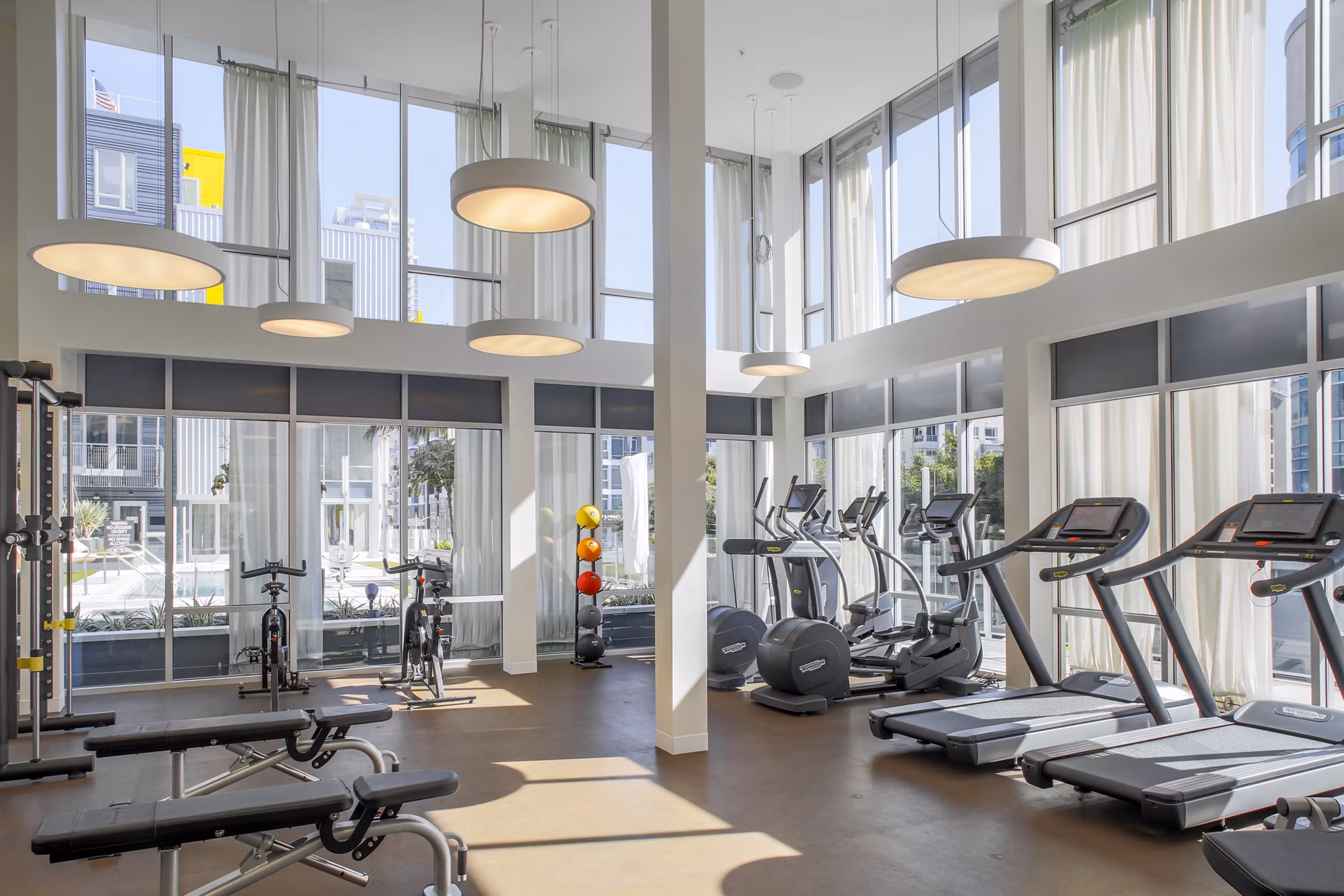 Fitness center with modern equipment at mResidences Olympic & Olive Apartments