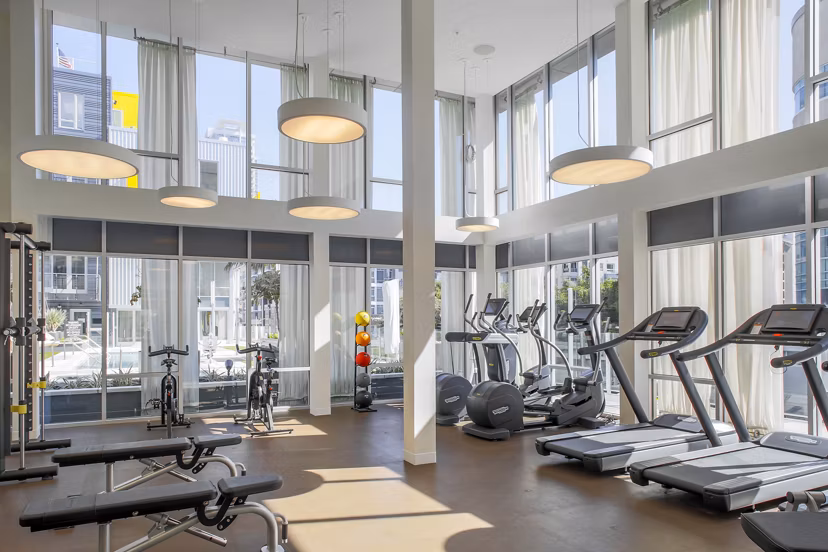 Fitness center with modern equipment at mResidences Olympic & Olive Apartments