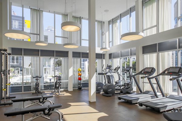Fitness center with modern equipment at mResidences Olympic & Olive Apartments