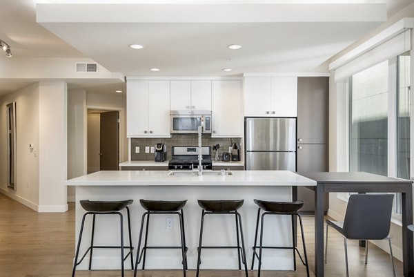 Spacious kitchen with sleek countertops and modern appliances at mResidences Olympic & Olive Apartments in Seattle