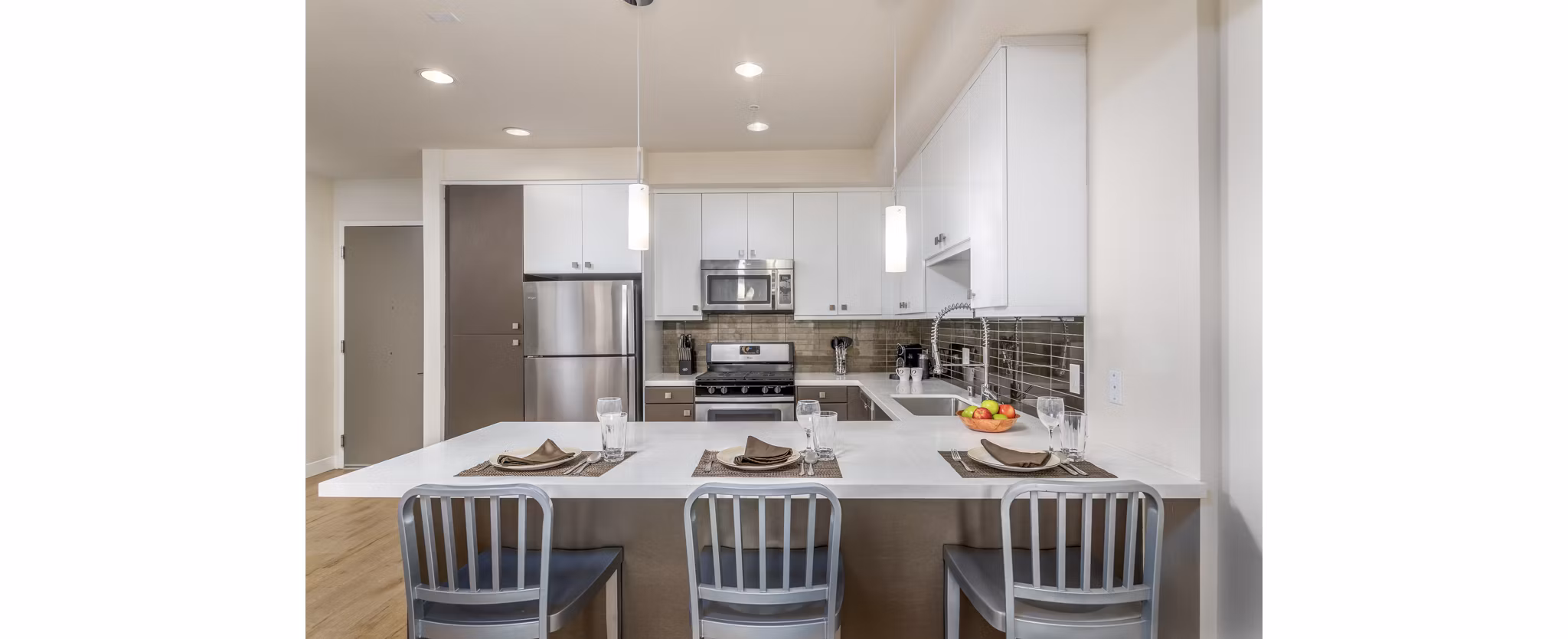 Modern kitchen with stainless steel appliances at mResidences Olympic & Olive Apartments