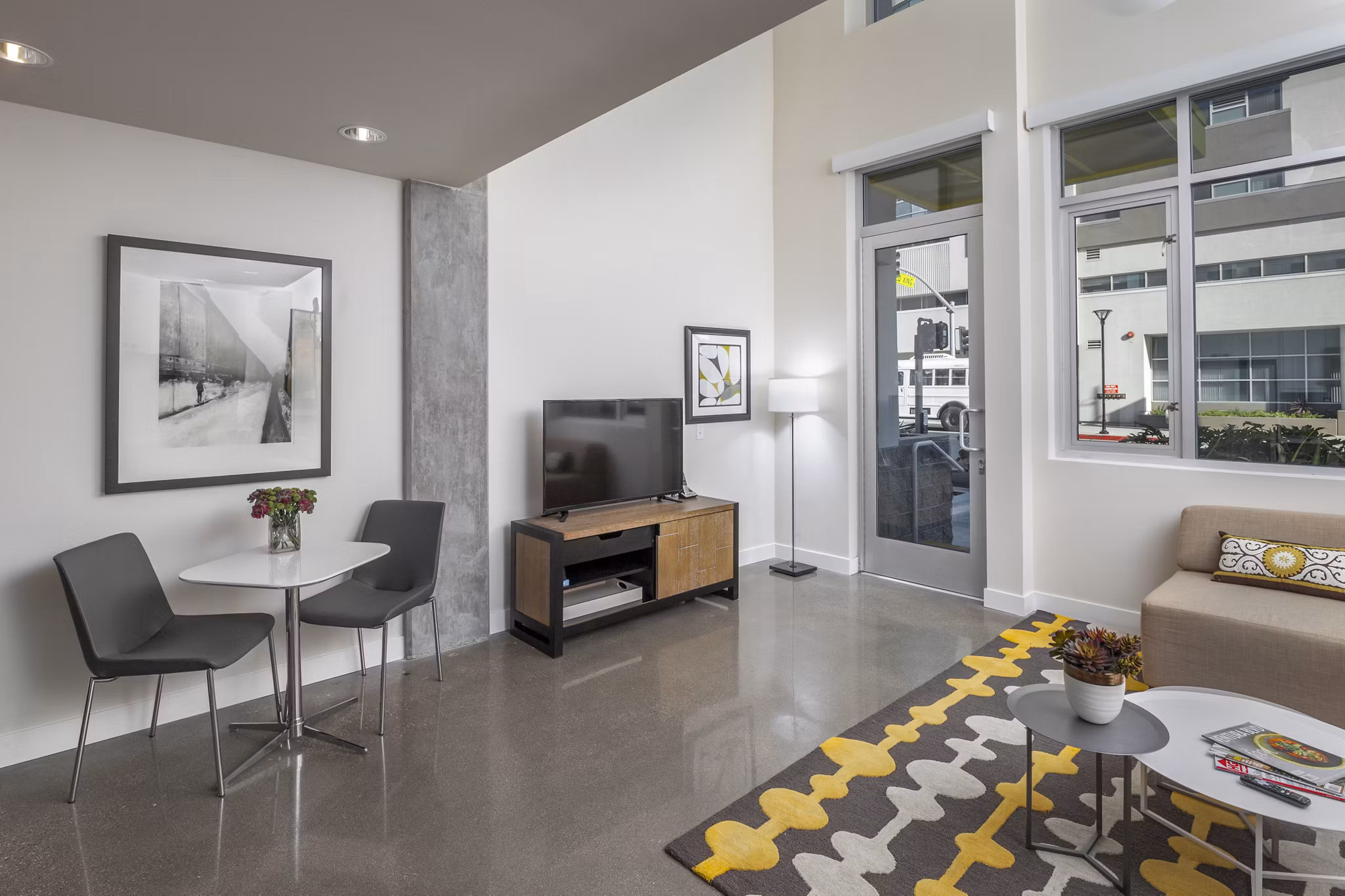 Spacious living room with modern dÃ©cor and large windows in mResidences Olympic & Olive Apartments
