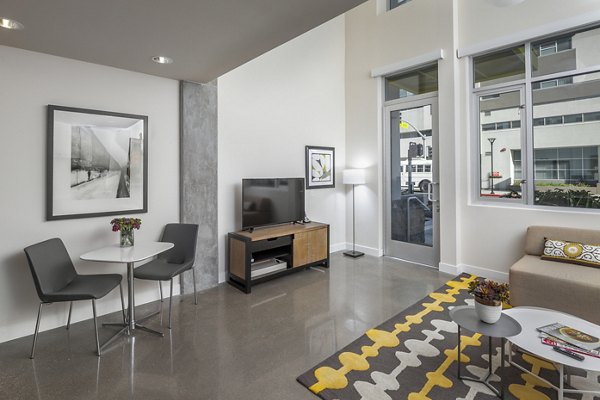 Spacious living room with modern dÃ©cor and large windows in mResidences Olympic & Olive Apartments