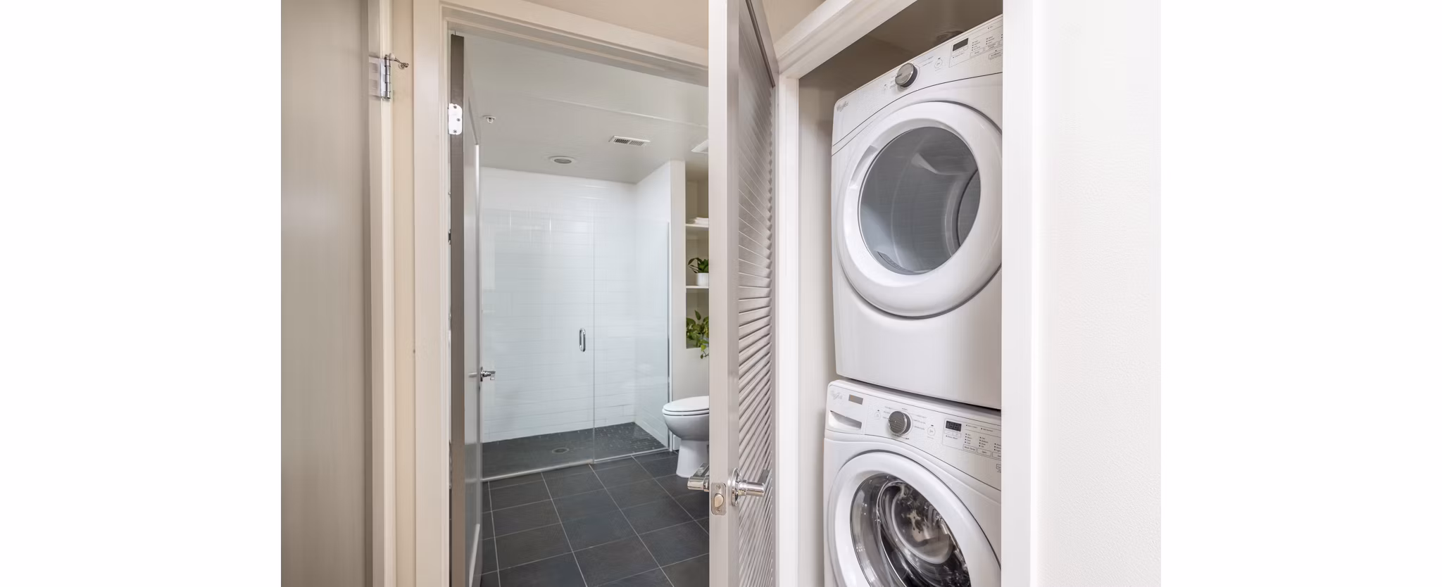 Laundry room equipped with modern appliances at mResidences Olympic & Olive Apartments, offering convenience and style for apartment living