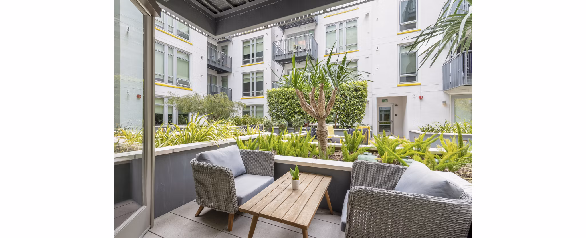 Chic patio space at mResidences Olympic & Olive Apartments with stylish seating and city views