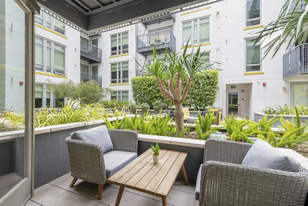 Chic patio space at mResidences Olympic & Olive Apartments with stylish seating and city views