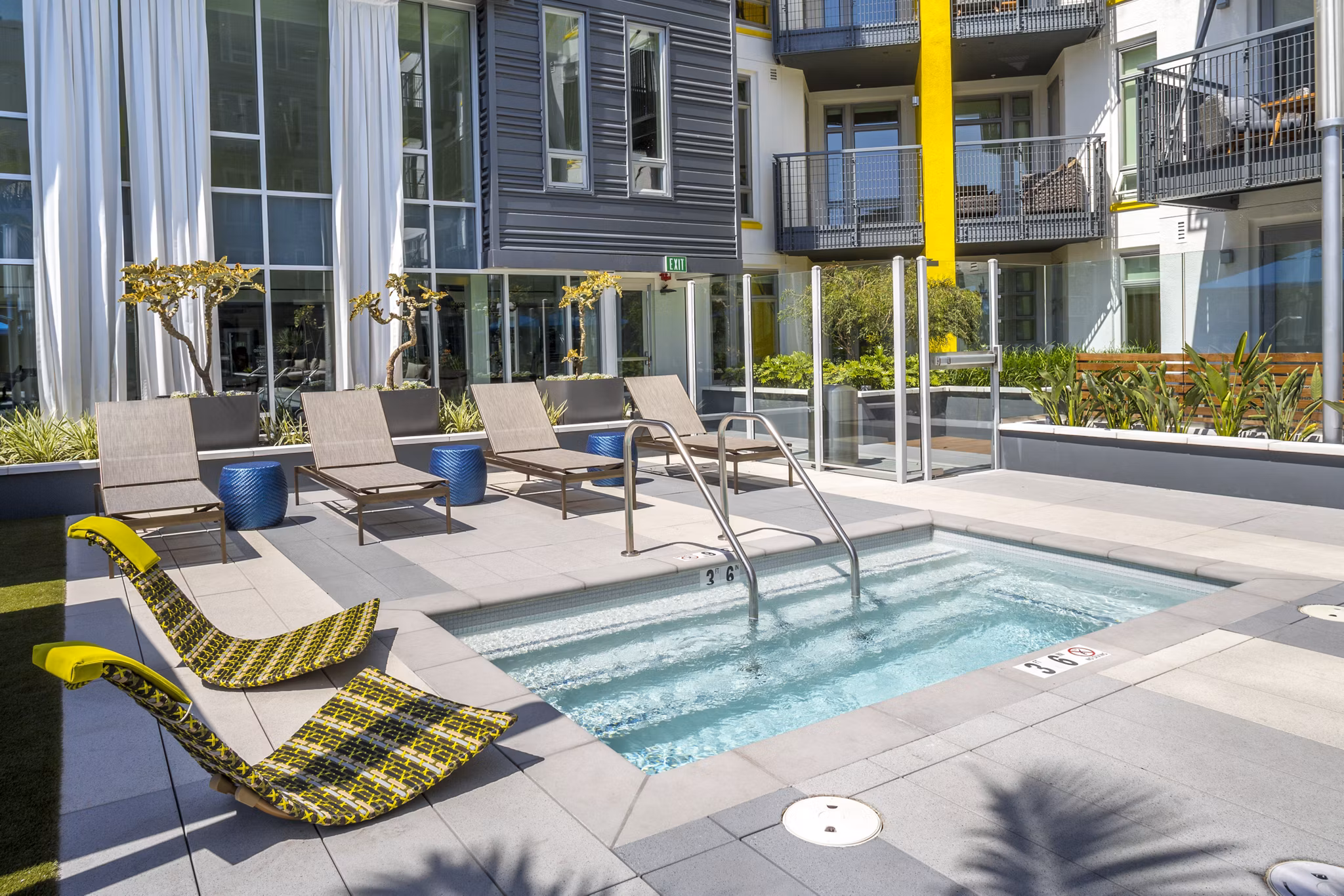 Inviting pool with lounge chairs at mResidences Olympic & Olive Apartments, perfect for relaxation and leisure