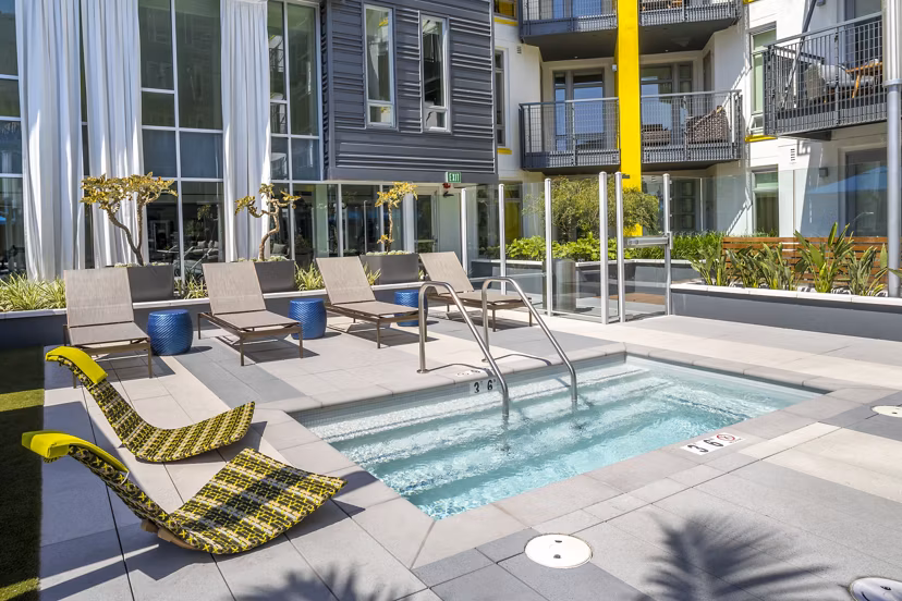 Inviting pool with lounge chairs at mResidences Olympic & Olive Apartments, perfect for relaxation and leisure