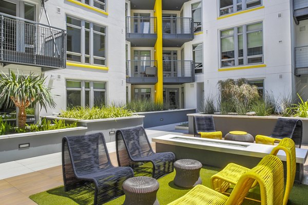 Fire pit with seating area at mResidences Olympic & Olive Apartments, a luxury community offering relaxation and socializing in Los Angeles