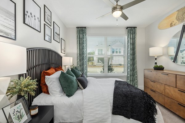 Bedroom with modern decor and large windows at Wentworth Park Apartments