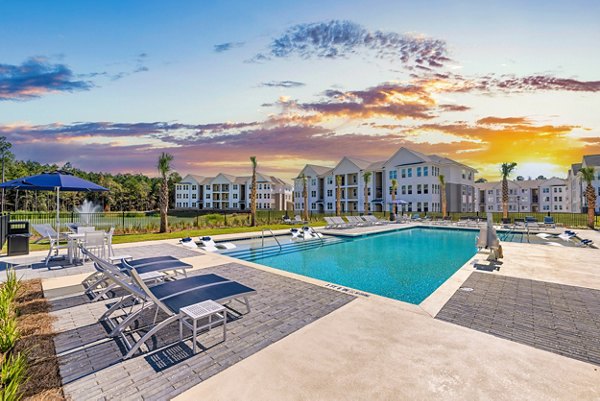 Resort-style pool with lounge chairs at Wentworth Park Apartments, ideal for relaxation and entertainment