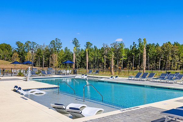 Resort-style pool with lounge chairs at Wentworth Park Apartments, offering luxurious outdoor relaxation in a vibrant community setting