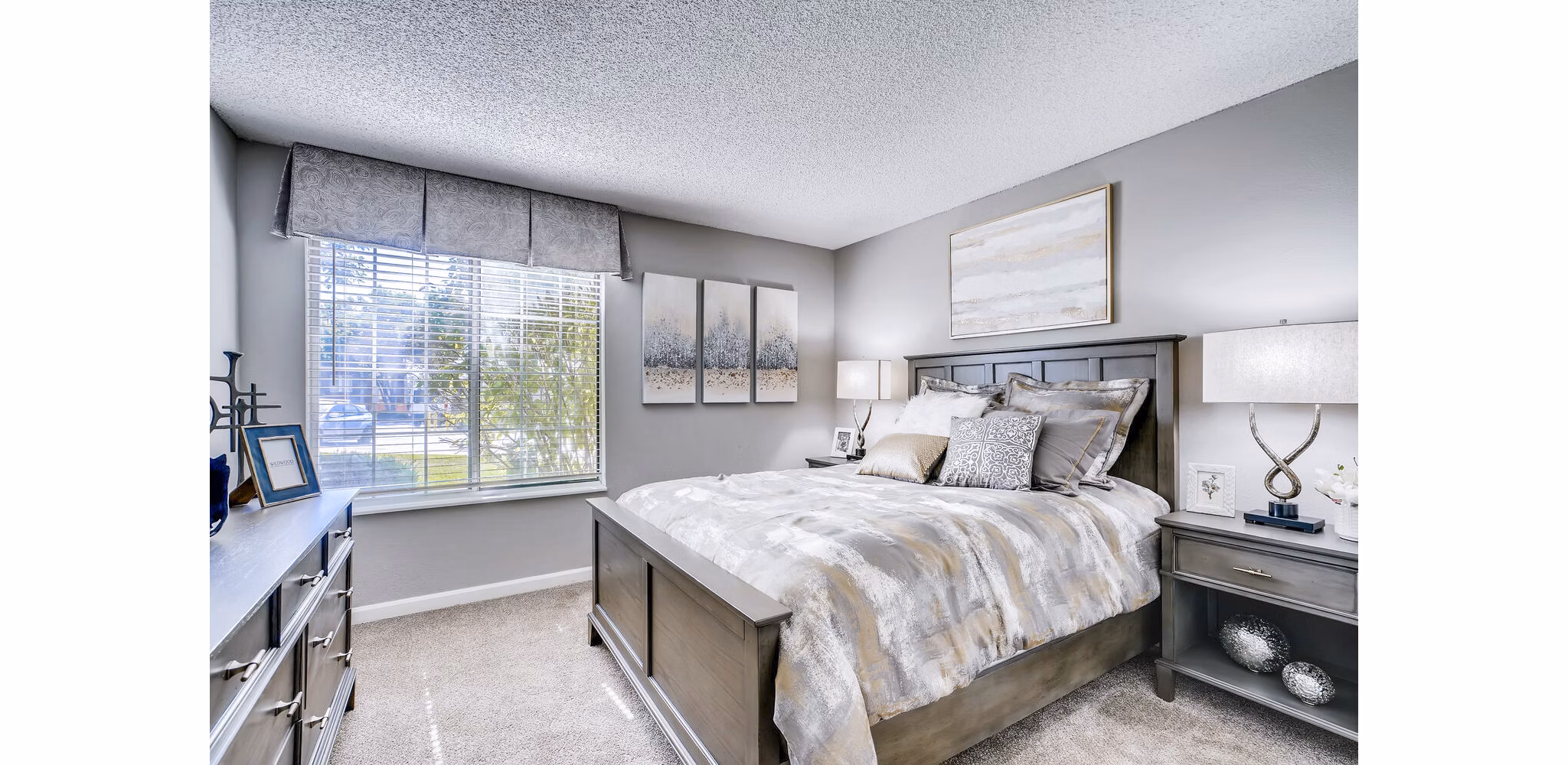 Cozy bedroom with contemporary design and large windows at Loretto Heights Apartments
