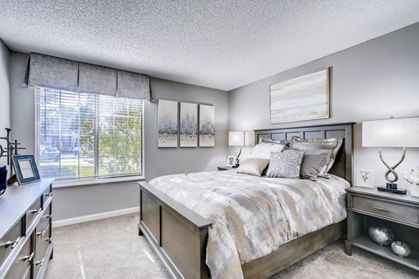 Cozy bedroom with contemporary design and large windows at Loretto Heights Apartments