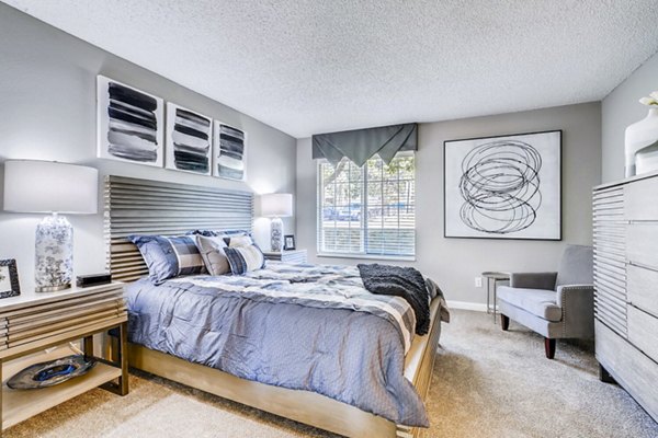 Cozy bedroom with plush bedding and natural light at Loretto Heights Apartments, offering luxury living by Greystar