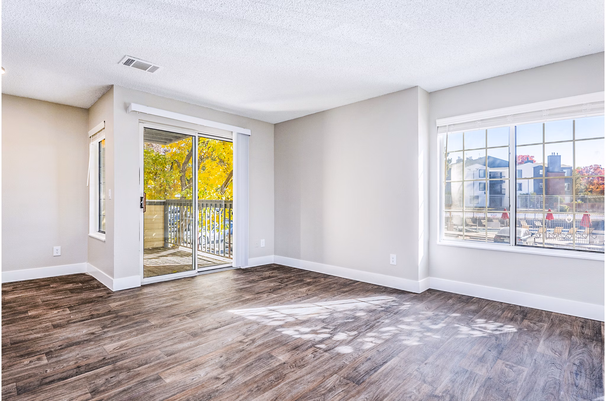 Inviting living room with modern decor and large windows at Loretto Heights Apartments