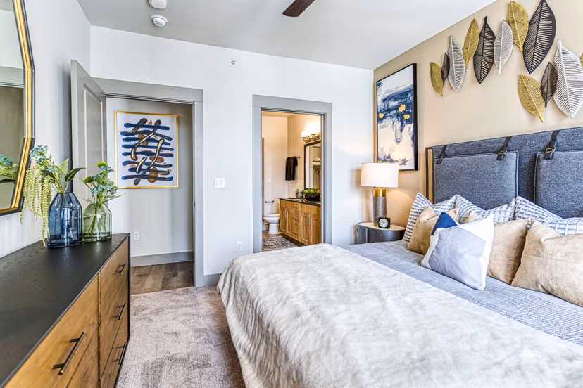 The Banks of Springdale Apartments: Cozy bedroom with contemporary decor and natural lighting