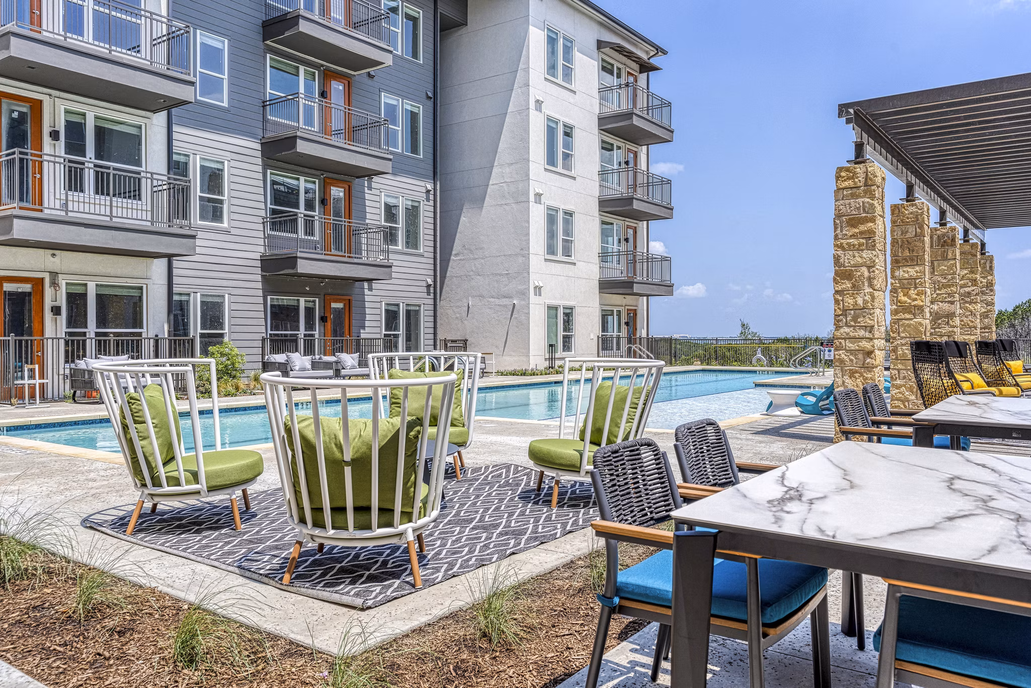 Modern outdoor pool patio with lounge seating at The Banks of Springdale Apartments, perfect for relaxation and leisure activities