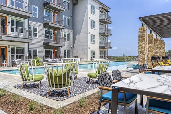 Modern outdoor pool patio with lounge seating at The Banks of Springdale Apartments, perfect for relaxation and leisure activities