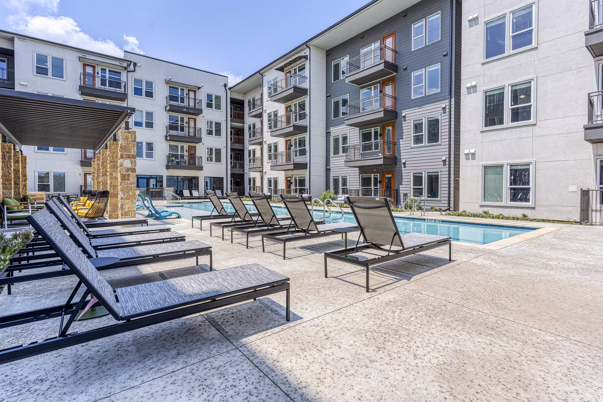 Resort-style pool with sun loungers at The Banks of Springdale Apartments