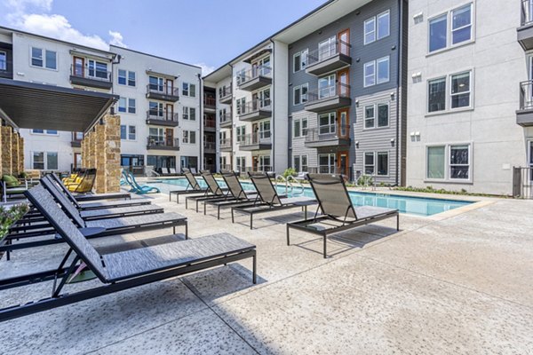 Resort-style pool with sun loungers at The Banks of Springdale Apartments