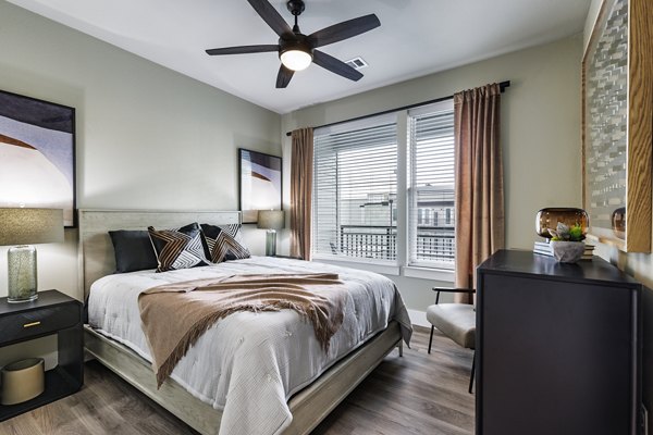 Spacious bedroom with modern furnishings at Urban East Apartments