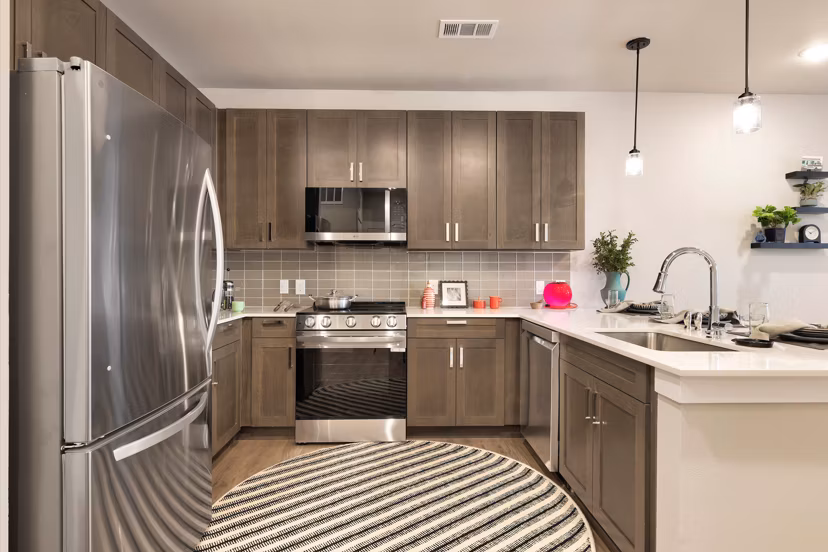 Modern kitchen with stainless steel appliances and granite countertops at Urban East Apartments