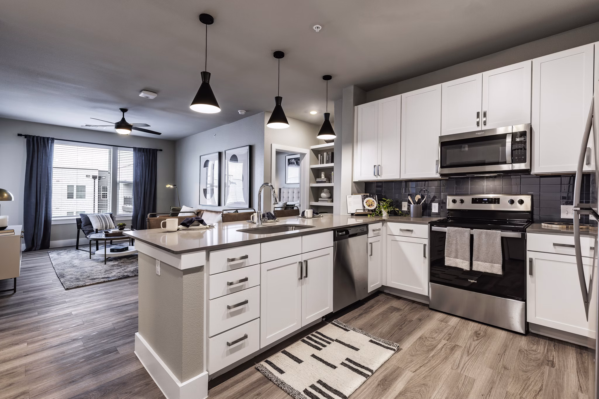 Modern kitchen with stainless steel appliances and granite countertops at Urban East Apartments