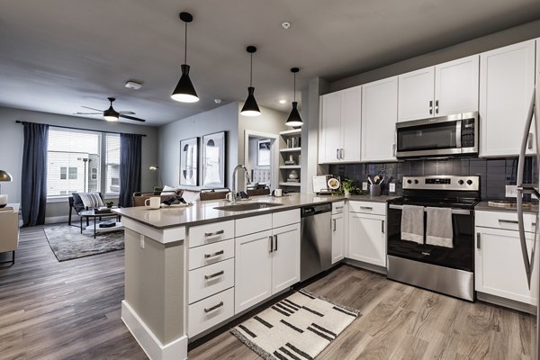 Modern kitchen with stainless steel appliances and granite countertops at Urban East Apartments