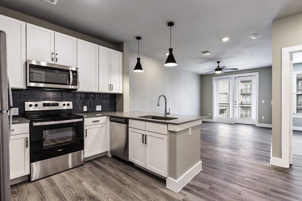 Modern kitchen with sleek cabinetry and stainless steel appliances in Urban East Apartments
