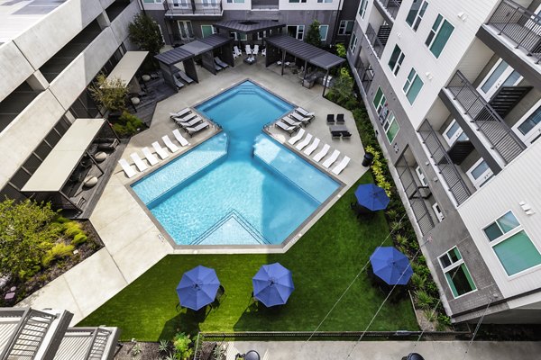 Luxurious pool with sun loungers at Urban East Apartments, a Greystar property