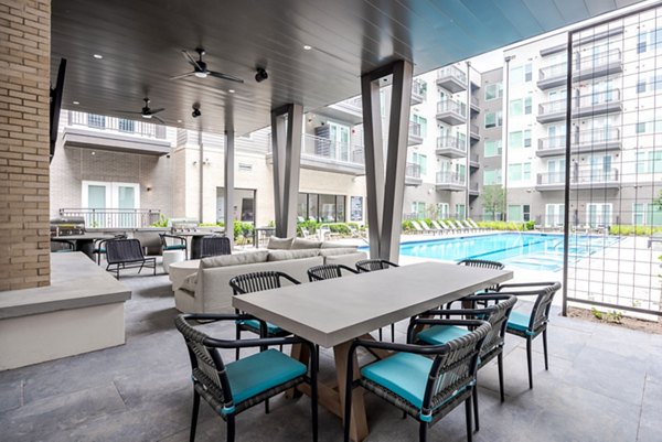 Pool patio with lounge chairs and greenery at Urban East Apartments, perfect for relaxation in a luxury setting