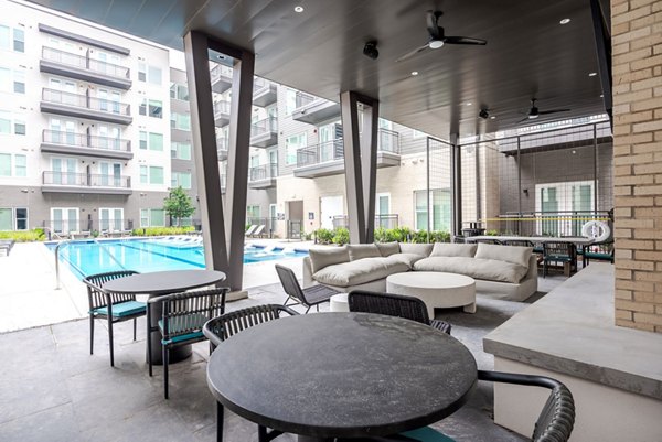 Outdoor pool patio area at Urban East Apartments featuring lounge seating and landscaped surroundings