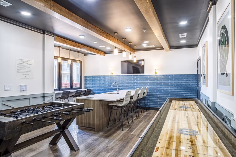 Clubhouse game room with pool table and flat-screen TV at West End Apartments: Luxury leisure space in Greystar's vibrant community