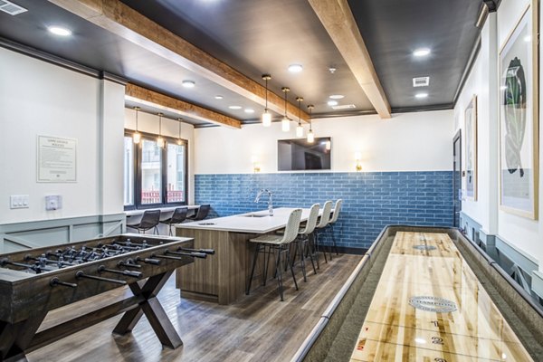 Clubhouse game room with pool table and flat-screen TV at West End Apartments: Luxury leisure space in Greystar's vibrant community