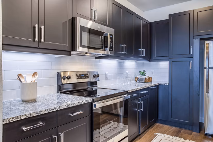 Modern kitchen with stainless steel appliances at West End Apartments