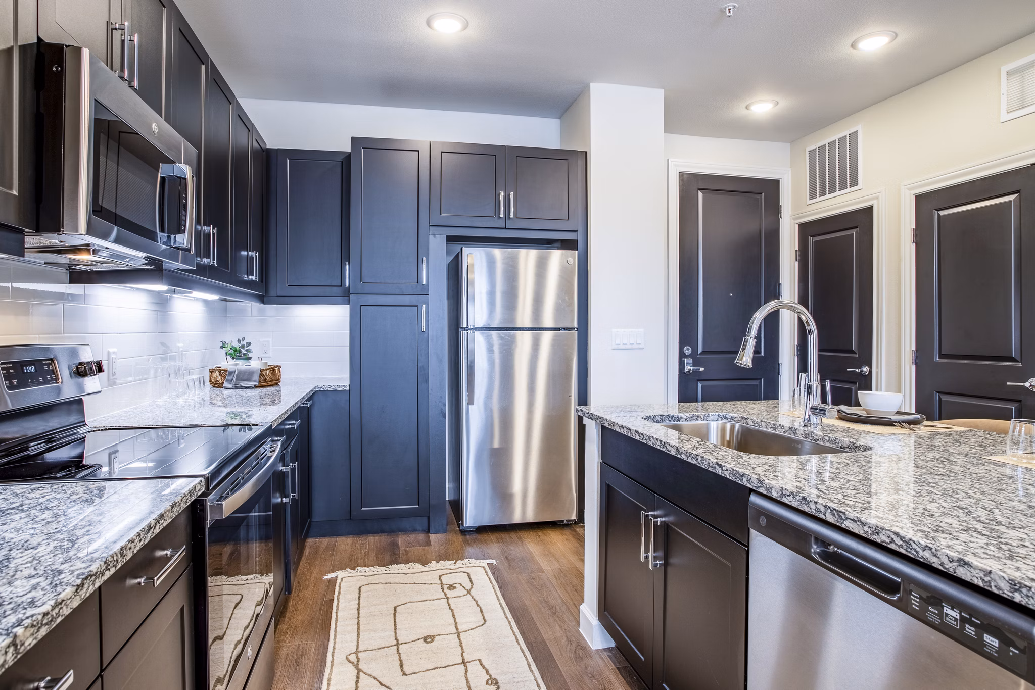 Modern kitchen with stainless steel appliances at West End Apartments, offering luxury living in the heart of the city